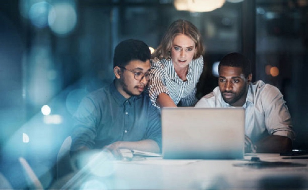 three workmates facing a laptop working on something x 1000 size